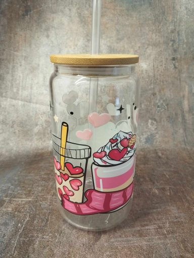 Un verre décoré avec des illustrations de desserts et une paille en plastique.